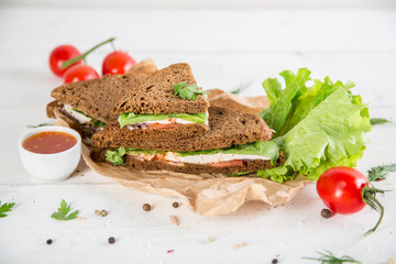 Club sandwich with chiken and cucumbers on dark rye bread