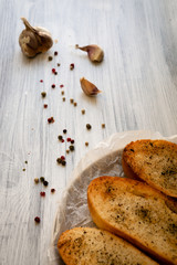 Golden croutons with garlic and ground black pepper. Toasted appetizer for soup or salad on a white wooden surface