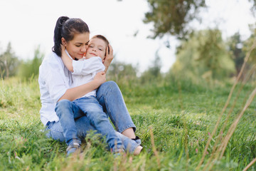Stilish mother and handsome son having fun on the nature. Happy family concept. Beauty nature scene with family outdoor lifestyle. Happy family resting together. Happiness in family life. Mothers day.