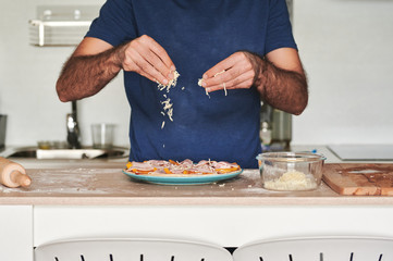 headless portrait of a man making homemade pizza