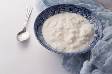 close up of fresh yogurt in a bowl on color background 