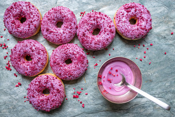 Pink round donuts at grey stone background