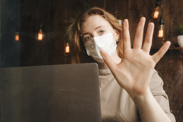 Quarantine stay at home. Bored and worried woman working alone at home in the medicine mask