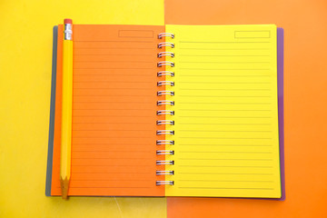  open colorful notepad and pencils on color background 