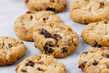 Homemade cranberry cookies on marble background, close up.