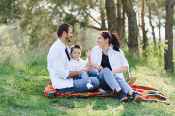 happy young couple with their children have fun at beautiful park outdoor in nature