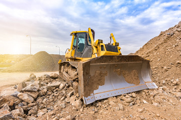 Excavator moving stone and rock at a construction site © Enrique del Barrio