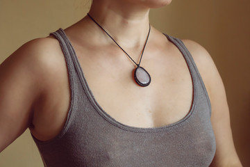Female neckline wearing elegant necklace with natural mineral gemstone