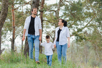 Fototapeta premium Dad, mom and little son having fun together, outdoors. Family walk in park. Happy family outdoors. Family, vacation concept