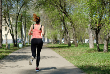 Young sporty woman jogging at park. Concept of healthy lifestyle and weight loss.