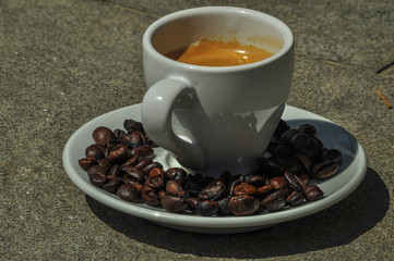cup of coffee over a lot of coffee beans background 