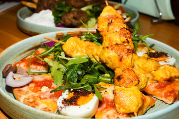 Chicken tandoori with rucola salad, egg with sumac spice, pitta bread. Asian dish