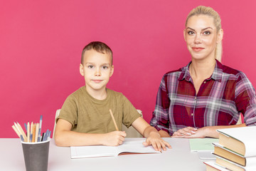 Homework together at quarantine concept. Mother with kid sitting at the desk with books and studying