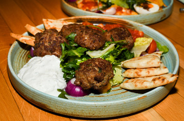 Mediterranean meatballs with salad, chickpeas with tomato sauce, yogurt dip and pita bread