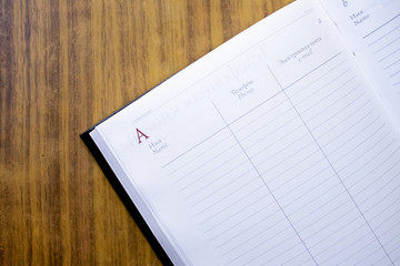 an open notebook or diary rests on a brown wooden background, a notebook.