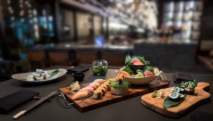 Selection of sushi sashimi nigiri specialties platter in a blurred restaurant setting
