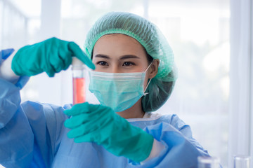 Asian Young woman scientist looking through a microscope in a laboratory. Young scientist doing some research.