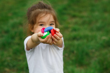 A little girl holds plastic bottle caps in her hands. Volunteer charity event "Good lids" to help orphaned children.