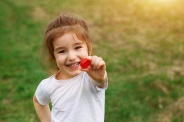 A little girl holds plastic bottle caps in her hands. Volunteer charity event "Good lids" to help orphaned children.