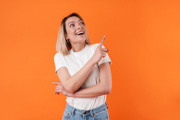 Image of excited caucasian woman smiling and pointing finger upward