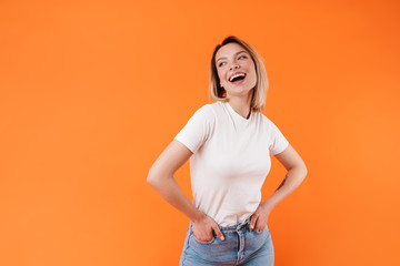 Image of joyful pretty woman laughing and posing with hands in pockets