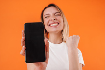 Naklejka premium Image of woman making winner gesture while showing mobile phone