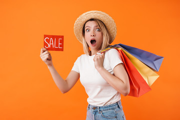 Image of shocked woman holding shopping bags and sale banner