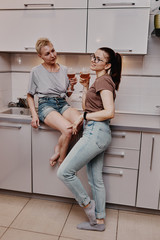 Two girls chatting with each other in the kitchen, love relationship same-sex couple girls. Family and family relationships.