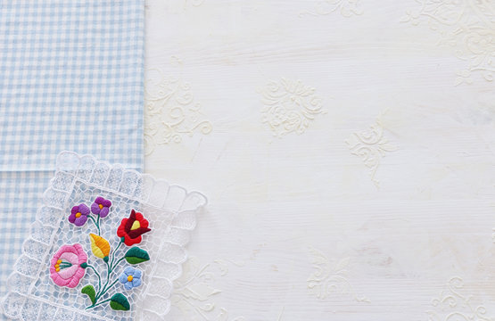top view of checkered tablecloth with over white wooden background © tomertu