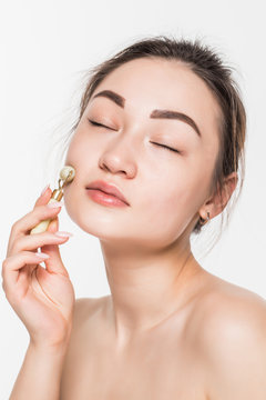 Beauty Rose Jade Stone Face Roller For Facial Massage Therapy. Portrait Of Asian Woman Use Jade Aging Roller Isolated On White Background.