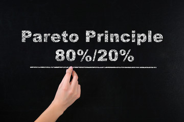 Fototapeta premium Pareto principle concept. Woman writing 80%/20% on chalkboard, closeup