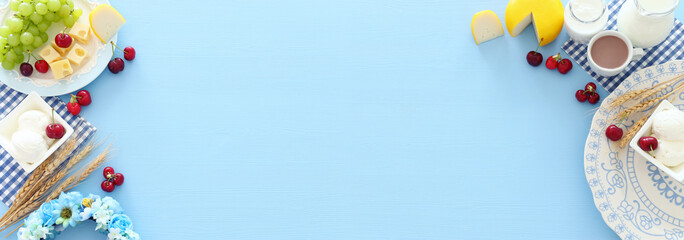 Top view photo of dairy products over pastel blue background. Symbols of jewish holiday - Shavuot
