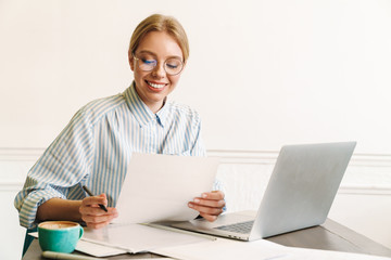 Photo of woman architect working with laptop while designing draft