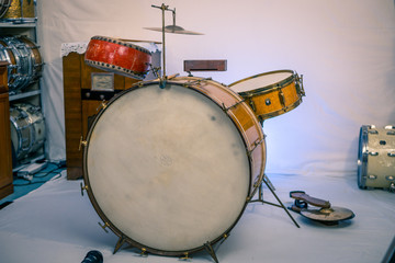 Fototapeta na wymiar Vintage/antique drum kit from the 1930s. Gold sparkle finish with red china tom tom and low boy cymbal