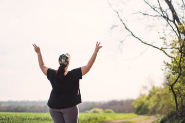 Life goals and achievement. Happy woman standing in nature. Female runner raising arms expressing...