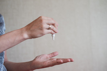 Sanitation is a means of protecting against the spread of Covid-19. A drop of disinfectant gel from a compact bottle.