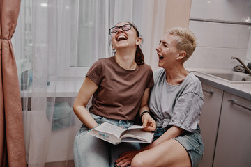 Two girls chatting with each other in the kitchen, love relationship same-sex couple girls. Family and family relationships.