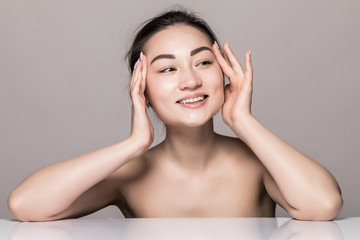 Closeup portrait of young woman face skin care with cosmetics isolated on gray background