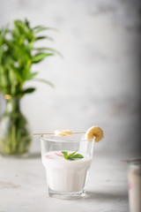 Banana smoothie with slice of bananas on a kitchen table. Rich taste drink