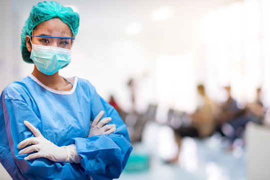 Doctors or surgeons wearing surgical mask with blur patient crowd background in hospital , during coronavirus or covid-19 crisis, medical concept.