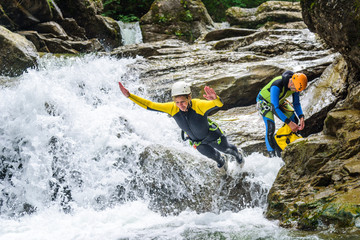 Mutiger Sprung ins schäumende Wasser eines Gebirgsbachs beim Canyoning