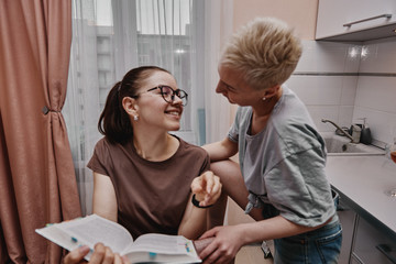 Obraz premium Two girls chatting with each other in the kitchen, love relationship same-sex couple girls. Family and family relationships.