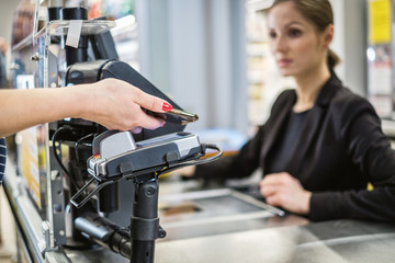 Fototapeta na wymiar Paying with ca smartphone in a grocery store