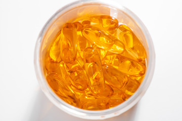 Close-up on bottle of Omega-3 capsules on white background, top view