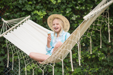 Girl in a hammock enjoys the sunny day, Summertime fun.