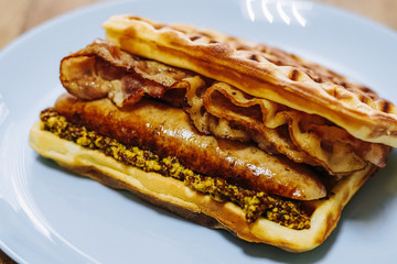 tasty Belgium waffle with lettuce, meat, egg and vegetables served of pretty blue plate