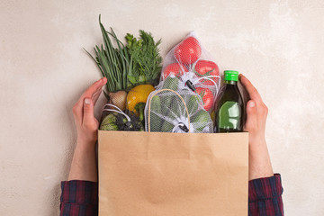 Man holds products in a paper bag. Vegetables in the range of shopping in the terrestrial and...