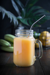 Fresh smoothies with banana on dark wooden background. Close up.