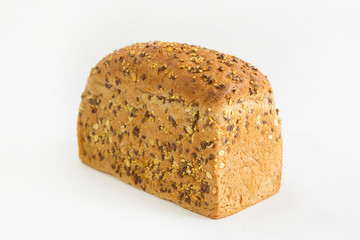 Delicious brick form bread baked at home. Crispy whole loaf with cereals, oats, seeds isolated on white background. Studio shot. Side view. Homemade bakery and nutrition concept