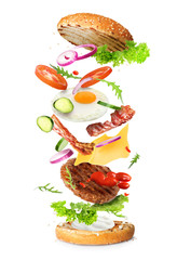 Delicious burger with different flying ingredients on white background